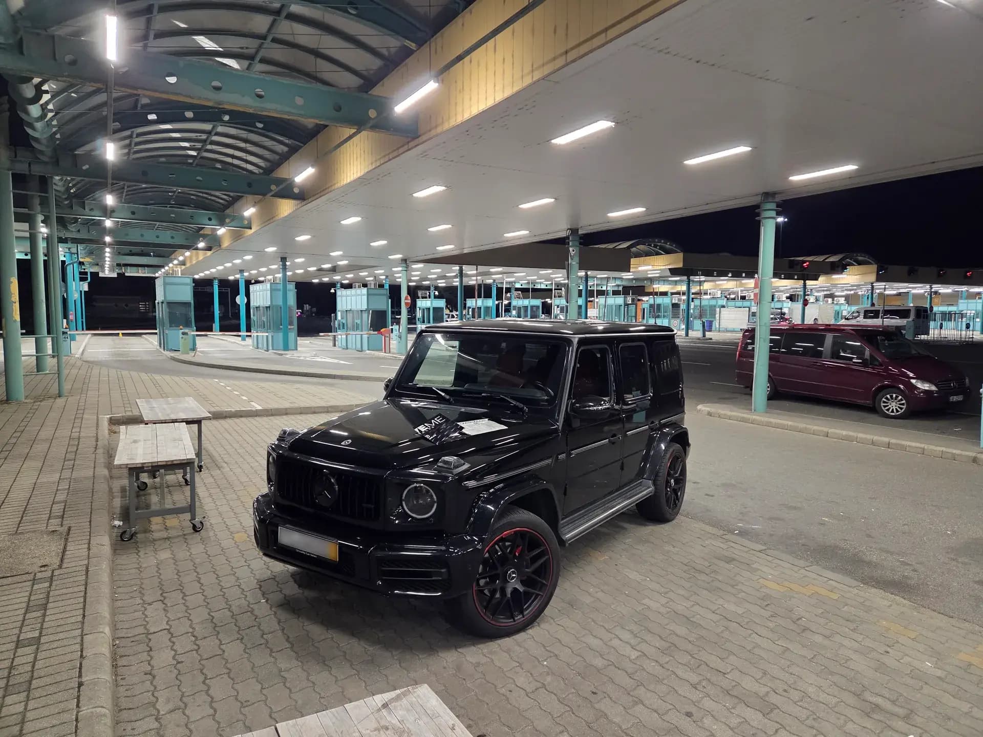 Crni Mercedes G-Class ispred aerodromskog terminala noću — VIP aerodromski transfer